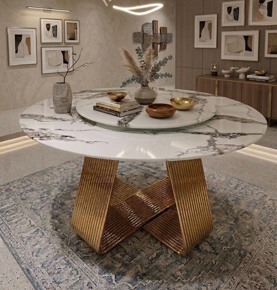 A round marble dining table on a sculpted gold base, with hand-thrown bowls.